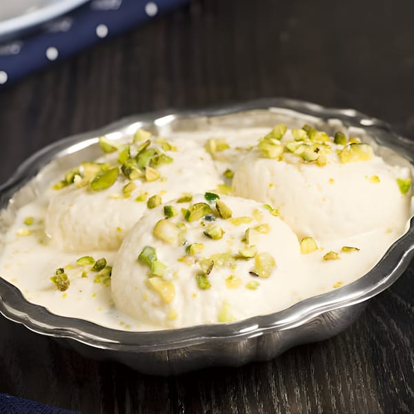 Annapurna Eats' Rasmalai, a creamy Indian dessert with soft cheese dumplings and chopped pistachios.